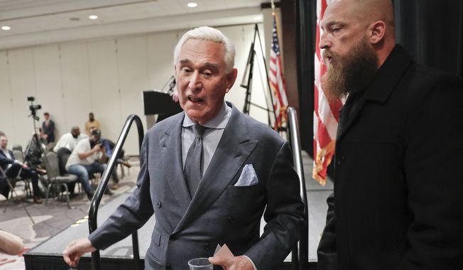 Roger Stone, center, longtime friend and confidant of President Donald Trump, walks next to a member of his private hired security, right, as he walks off stage after speaking to members of the media in Washington, Thursday, Jan. 31, 2019. (AP Photo/Pablo Martinez Monsivais)