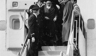 FILE - In this Feb. 1, 1979 file photo, Ayatollah Ruhollah Khomeini, Iran&#39;s exiled religious leader, emerges from a plane after his arrival at Mehrabad airport in Tehran, Iran. Friday, Feb. 1, 2019, marks the 40th anniversary of Khomeini&#39;s descent from the chartered Air France Boeing 747, a moment that changed the country’s history for decades to come. (AP Photo/FY, File)