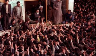 FILE - In this Feb. 2, 1979 file photo, Ayatollah Ruhollah Khomeini, center, is greeted by supporters in Tehran, Iran. Friday, Feb. 1, 2019 marks the 40th anniversary of Iran’s exiled Ayatollah Ruhollah Khomeini return to Tehran, a moment that changed the country’s history for decades to come. That revolution would spark the U.S. Embassy takeover and hostage crisis, stoking the animosity that exists between Tehran and Washington to this day. (AP Photo, File)