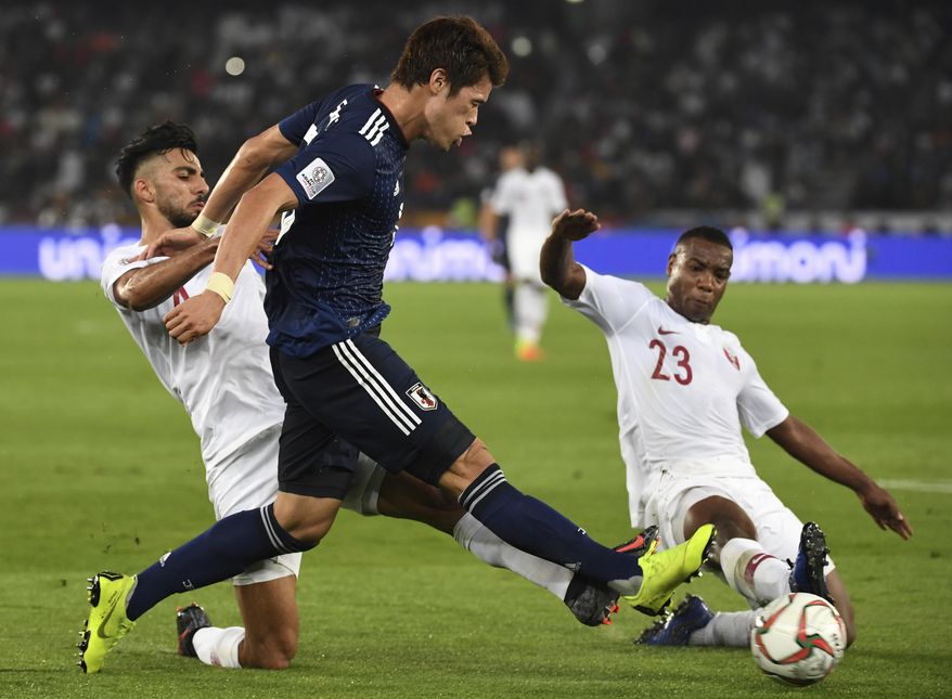 Qatar's defender Tarek Salman, left, and Qatar's defender Assim Madibo, right, challenge Japan's defender Hiroki Sakai, center, during the AFC Asian Cup final match between Japan and Qatar in Zayed Sport City in Abu Dhabi, United Arab Emirates, Friday, Feb. 1, 2019. (AP Photo/Hassan Ammar)