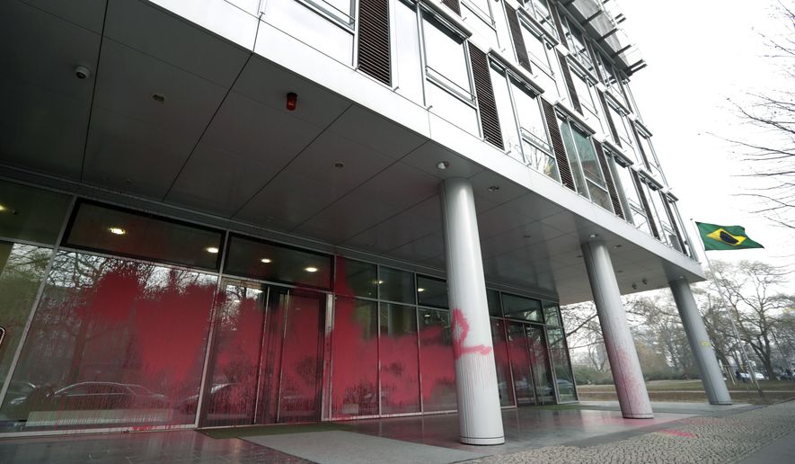 The entrance of the embassy of Brazil is covered with red color after unknown persons threw paint at the building in Germany in Berlin, Germany, Friday, Feb. 1, 2019. (AP Photo/Michael Sohn)
