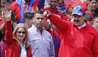 President Nicolas Maduro and first lady Cilia Flores greet supporters as they arrive at a rally in Caracas, Venezuela, Saturday, Feb. 2, 2019. Maduro called the rally to celebrate the 20th anniversary of the late President Hugo Chavez&#39;s rise to power. (AP Photo/Ariana Cubillos)