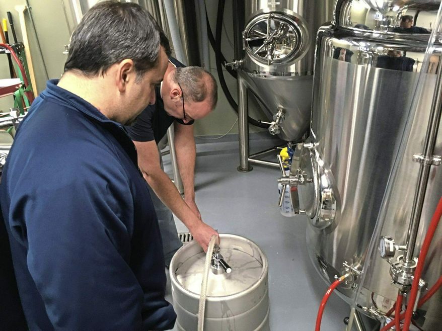 This photo taken Dec. 20, 2018, shows John Titus fills a keg with beer at the New Crescent Brewing Co. brewery in downtown Irwin. Titus and Tim Molinari, the brewer, are partners in the brewpub that is expected to open later this month. (Joe Napsha/Pittsburgh Tribune-Review via AP)