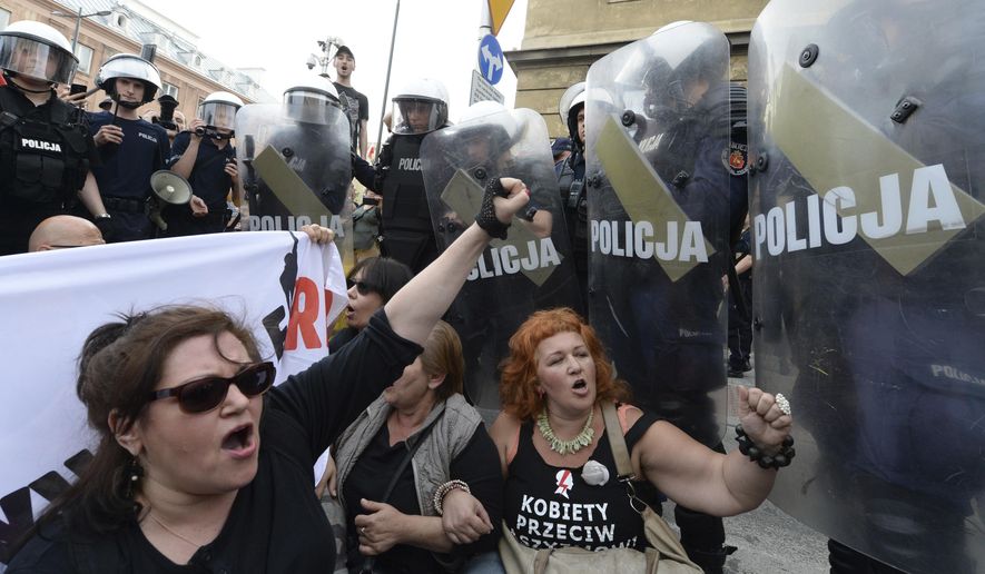 FILE - In this May 1, 2018, file photo, anti-fascists shout slogans against members of the far-right National-Radical Camp in Warsaw, Poland. Poland's political fissures have widened in recent months, pitting conservatives, many of them government supporters, against liberal critics who accuse the leadership of threatening the country's hard-won democracy by undermining the independence of the judiciary and the media. (AP Photo/Czarek Sokolowski, File)