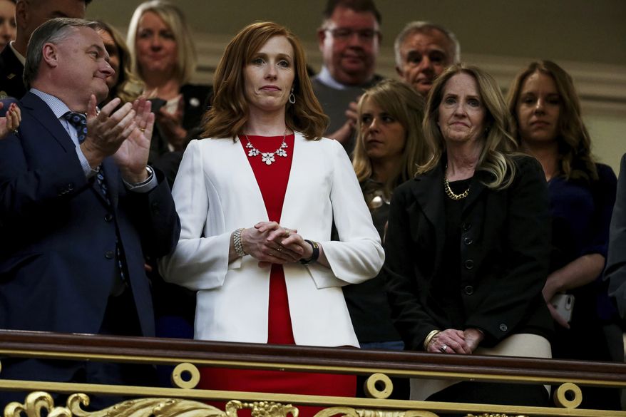 Jennie Taylor, center, wife of slain Utah National Guard Maj. Brent Taylor, and Tammy Taylor, Maj. Taylor's mother, stand as the House chamber audience rises to honor the families of Utahns who fell in the line of duty in the last year during Utah Gov. Gary Herbert's State of the State address at the Utah State Capitol Wednesday, Jan. 30, 2019, in Salt Lake City. (Spenser Heaps/Deseret News, via AP, Pool)