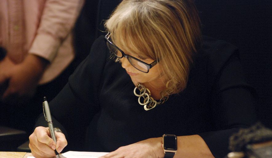 New Mexico Gov. Michelle Lujan Grisham signs a bill, Monday, Feb. 4, 2019, in Santa Fe, N.M. The governor signed 42 initiatives that were vetoed by her Republican predecessor in previous years that span issues from teacher pensions to child foster care and public disclosures by lobbyists. (AP Photo/Morgan Lee)