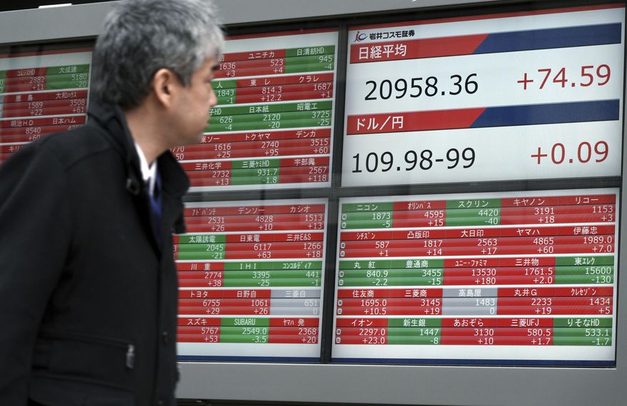 A man looks at an electronic stock board showing Japan's Nikkei 225 index at a securities firm in Tokyo Tuesday, Feb. 5, 2019. Shares are lower in most markets open in Asia with much of the region taking a break for the Lunar New Year.(AP Photo/Eugene Hoshiko)