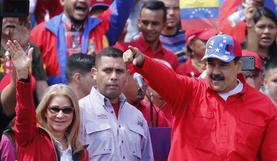 President Nicolas Maduro and first lady Cilia Flores greet supporters as they arrive at a rally in Caracas, Venezuela, Saturday, Feb. 2, 2019. Maduro called the rally to celebrate the 20th anniversary of the late President Hugo Chavez&#39;s rise to power. (AP Photo/Ariana Cubillos)