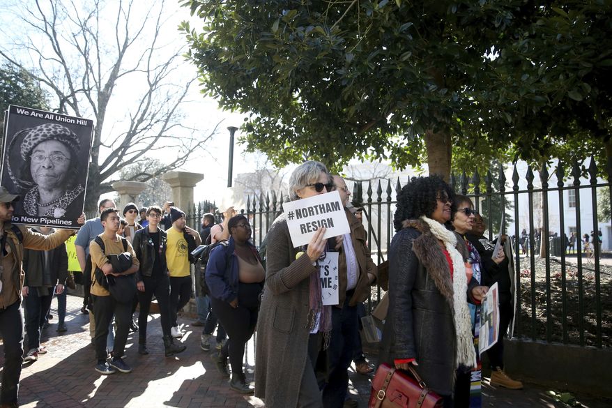 People march near the capitol during a protest in Richmond calling for Virginia Governor Ralph Northam to resign on Monday Feb. 4, 2019. Robert Stamm, a Virginia police sergeant assigned to monitor recent protests near the residence of Gov. Ralph Northam, was placed on administrative leave on Feb. 6 after activists accused him of having "explicit, overt ties" to a white nationalist organization. (Shelby Lum/Richmond Times-Dispatch via AP) **FILE**
