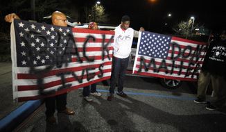 Activists protesting the police shooting of a black man in an Alabama shopping mall hold U.S. flags painted with the words &amp;quot;Black lives don&#39;t matter&amp;quot; in Hoover, Ala., Tuesday, Feb. 5, 2019. Demonstrators are upset with the state&#39;s decision against prosecuting a police officer who shot and killed Emantic &amp;quot;EJ&amp;quot; Bradford Jr. in a shopping mall on Thanksgiving night. (AP Photo/Jay Reeves)