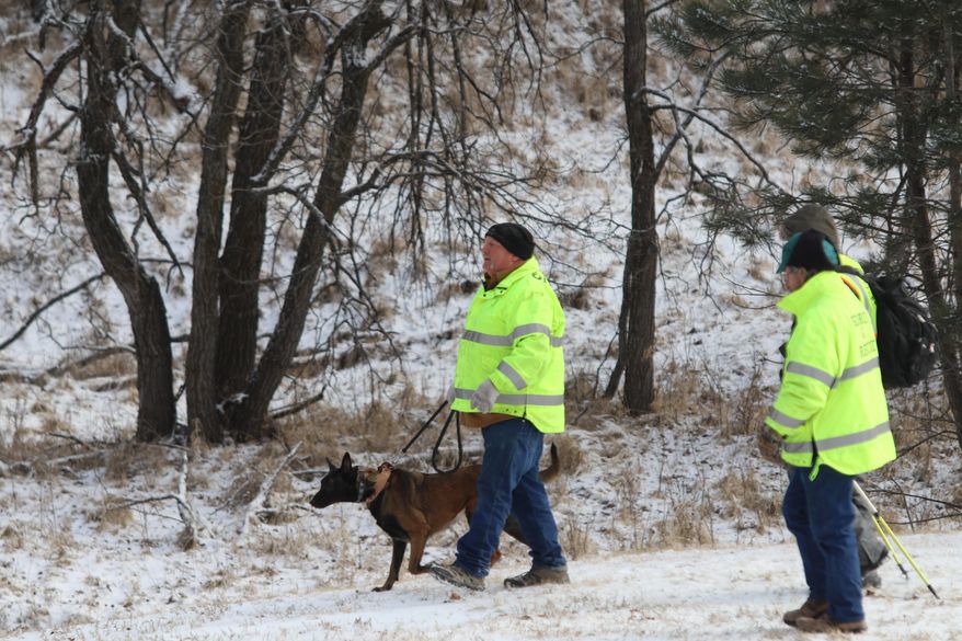 A dog helps search for Serenity Dennard, 9, Monday, Feb. 4, 2019, near Rockerville, S.D. Authorities say that the girl ran away from staff at a residential youth home. (Arielle Zionts/Rapid City Journal via AP)