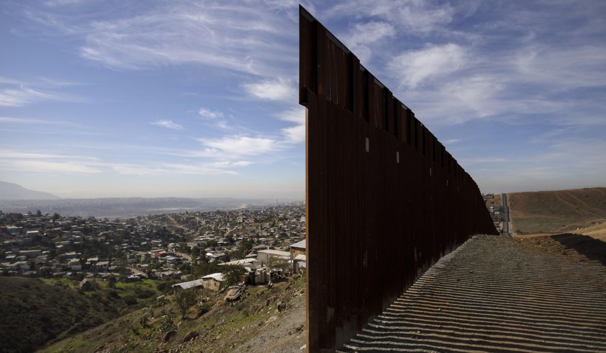 FILE - In this Dec. 22, 2018, file photo, Tijuana, Mexico, left, and San Diego, Calif, right, are seen separated by the U.S. border fence. (AP Photo/Daniel Ochoa de Olza, File)