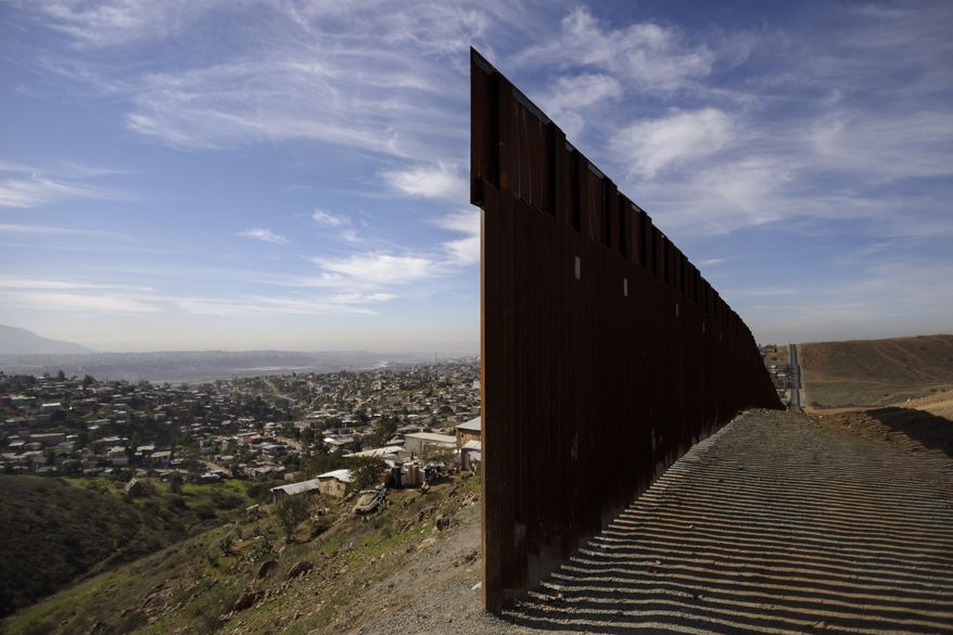 FILE - In this Dec. 22, 2018, file photo, Tijuana, Mexico, left, and San Diego, Calif, right, are seen separated by the U.S. border fence. (AP Photo/Daniel Ochoa de Olza, File)