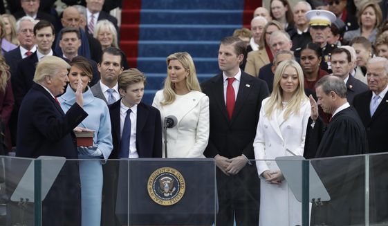 In this Jan. 20, 2017, file photo, Donald Trump, left, is sworn in as the 45th president of the United States by Chief Justice John Roberts, right, as Melania Trump, second left, and his family watch during the 58th Presidential Inauguration at the U.S. Capitol in Washington. (AP Photo/Patrick Semansky, File)