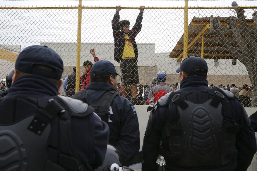 Central American immigrants hang around by the fence line of a shelter guarded by Mexican Federal police in riot gear in Piedras Negras, Mexico, Tuesday, Feb. 5, 2019. A caravan of about 1,600 Central American migrants camped Tuesday in the Mexican border city of Piedras Negras, just west of Eagle Pass, Texas. The governor of the northern state of Coahuila described the migrants as &amp;quot;asylum seekers,&amp;quot; suggesting all had express intentions of surrendering to U.S. authorities. (Jerry Lara/The San Antonio Express-News via AP) **FILE**