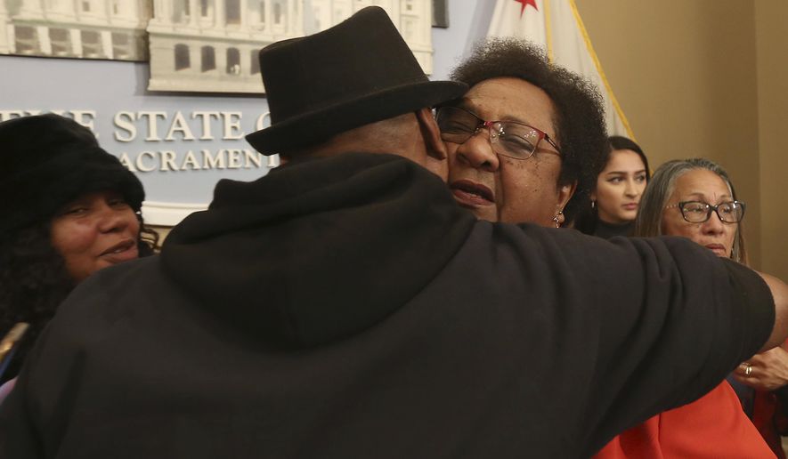 Assemblywoman Shirley Weber, D-San Diego, right, is hugged by Cephus Johnson, the uncle of Oscar Grant who was killed by BART police n 2009 after she announced her proposed bill that would allow police to use deadly force only when there is no reasonable alternative, Wednesday, Feb. 6, 2019, in Sacramento, Calif. Weber's measure is one of two competing proposal over when police can use deadly force. (AP Photo/Rich Pedroncelli)