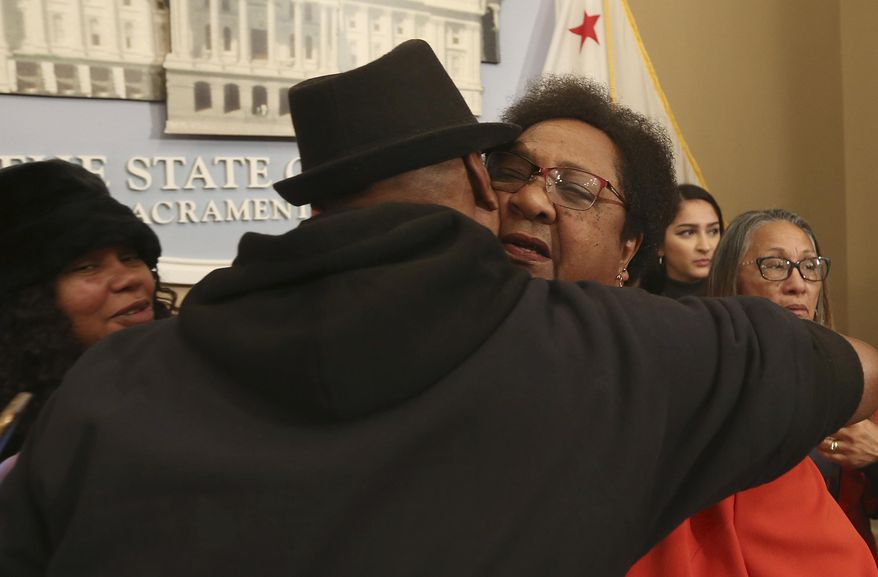 Assemblywoman Shirley Weber, D-San Diego, right, is hugged by Cephus Johnson, the uncle of Oscar Grant who was killed by BART police n 2009 after she announced her proposed bill that would allow police to use deadly force only when there is no reasonable alternative, Wednesday, Feb. 6, 2019, in Sacramento, Calif. Weber's measure is one of two competing proposal over when police can use deadly force. (AP Photo/Rich Pedroncelli)