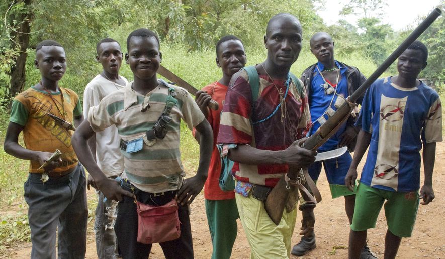 FILE - In this Tuesday, Nov. 26, 2013 file photo, fighters from a Christian militia movement known as the "anti-balaka" display their makeshift weaponry in the village of Boubou, halfway between the towns of Bossangoa and Bouca, in the Central African Republic. Central African Republic and 14 rebel groups signed a peace deal on Wednesday, Feb. 6, 2019 even as some expressed alarm about the possible suspension of prosecutions after five years of bloody conflict. (AP Photo/Florence Richard, File)