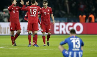 Hertha&#39;s Lukas Kluenter sits on the pitch as Bayern&#39;s players celebrate after a German Soccer Cup round of sixteen match between Hertha BSC Berlin and FC Bayern Munich in Berlin, Germany, Wednesday, Feb. 6, 2019. Munich defeated Berlin by 3-2. (AP Photo/Michael Sohn)