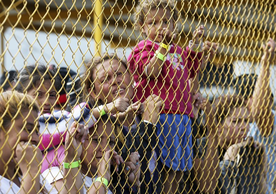 Central American immigrant families look out through the fence of a shelter in Piedras Negras, Mexico, Tuesday, Feb. 5, 2019. A caravan of about 1,600 Central American migrants camped Tuesday in the Mexican border city of Piedras Negras, just west of Eagle Pass, Texas. The governor of the northern state of Coahuila described the migrants as "asylum seekers," suggesting all had express intentions of surrendering to U.S. authorities. (Jerry Lara/The San Antonio Express-News via AP)