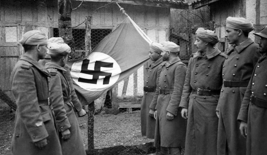 Displaying a Nazi flag seized in combat at the Western Front, these French North African soldiers look over their prize after the encounter on April 4, 1940. (AP Photo)