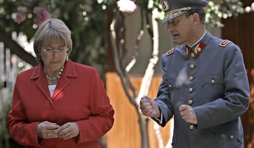 FILE - In this Jan. 17, 2006 file photo, then President-elect Michelle Bachelet talks with Army Chief Gen. Juan Emilio Cheyre, at her home in Santiago, Chile. Authorities say that Cheyre has been arrested and charged for involvement torturing 24 people following a 1973 military coup. The retired general was taken into custody Thursday, Feb. 7, 2019. (AP Photo/Santiago Llanquin, File)