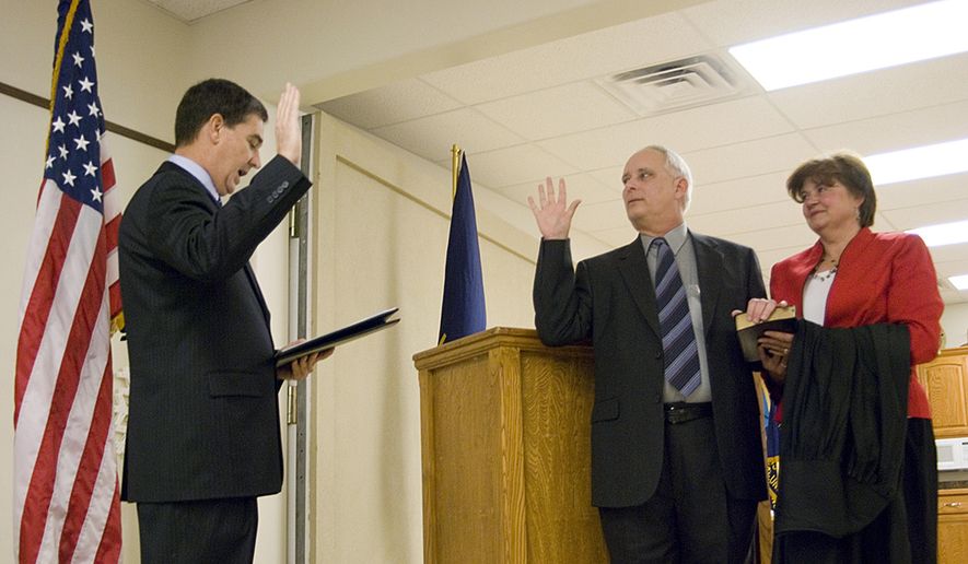 In this Dec. 19, 2008 photo, Michael Gibbens, center, stands next to his wife, Nancy, as he is sworn in as a Leavenworth County District Court judge by District Court Chief Judge David King, left, at the Veterans of Foreign Wars hall in Tonganoxie, Kan. The Kansas judge who blamed two young girls as the 'aggressor' in a sexual encounter with a 67-year-old man has spent a decade on the bench overseeing mostly sealed juvenile and child-in-need-of-care cases behind closed doors. But since Leavenworth County Judge Michael Gibbens took over the criminal docket for a retiring district judge this summer his rulings have drawn more public scrutiny and criticism. (Estuardo Garcia/The Journal-World via AP)