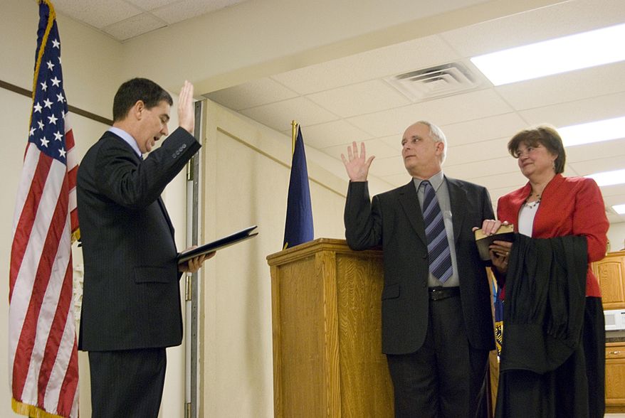 In this Dec. 19, 2008 photo, Michael Gibbens, center, stands next to his wife, Nancy, as he is sworn in as a Leavenworth County District Court judge by District Court Chief Judge David King, left, at the Veterans of Foreign Wars hall in Tonganoxie, Kan. The Kansas judge who blamed two young girls as the 'aggressor' in a sexual encounter with a 67-year-old man has spent a decade on the bench overseeing mostly sealed juvenile and child-in-need-of-care cases behind closed doors. But since Leavenworth County Judge Michael Gibbens took over the criminal docket for a retiring district judge this summer his rulings have drawn more public scrutiny and criticism. (Estuardo Garcia/The Journal-World via AP)
