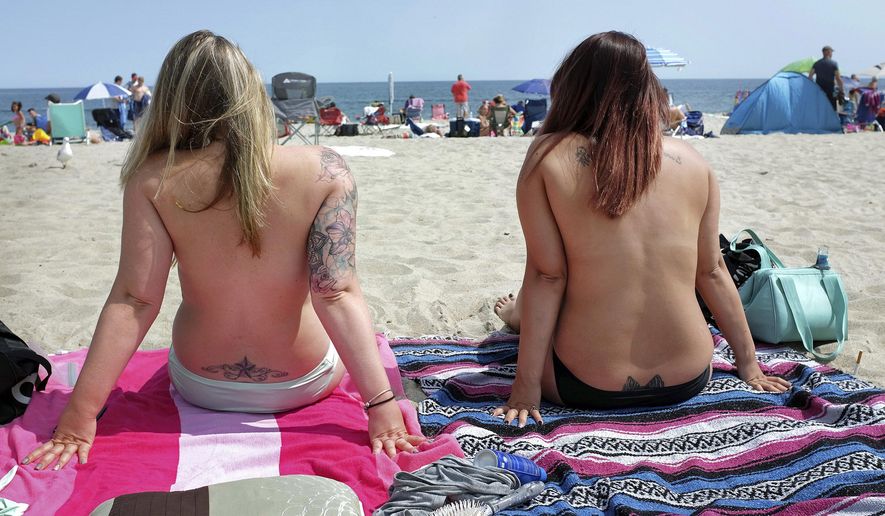 In this Aug. 26, 2017, photo, women go topless as they participate in the Free the Nipple global movement during Go Topless Day at Hampton Beach, N.H. Voters in Nantucket, Mass., have approved a bylaws amendment that will allow "any person... to be topless on any public or private beach within the Town of Nantucket." (Ioanna Raptis/Portsmouth Herald seacoastonline.com via AP) **FILE**