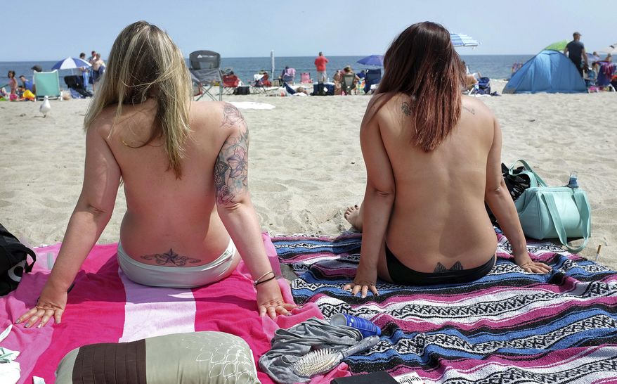 In this Aug. 26, 2017, photo, women go topless as they participate in the Free the Nipple global movement during Go Topless Day at Hampton Beach, N.H. Voters in Nantucket, Mass., have approved a bylaws amendment that will allow "any person... to be topless on any public or private beach within the Town of Nantucket." (Ioanna Raptis/Portsmouth Herald seacoastonline.com via AP) **FILE**