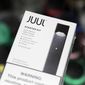 FILE - This Thursday, Dec. 20, 2018 file photo shows a Juul electronic cigarette starter kit at a smoke shop in New York. According to letters released on Friday, Feb. 8, 2019, the head of the Food and Drug Administration is questioning whether electronic cigarette maker Juul and its new partner Altria are following through on pledges to help reverse the current epidemic of underage vaping. (AP Photo/Seth Wenig)
