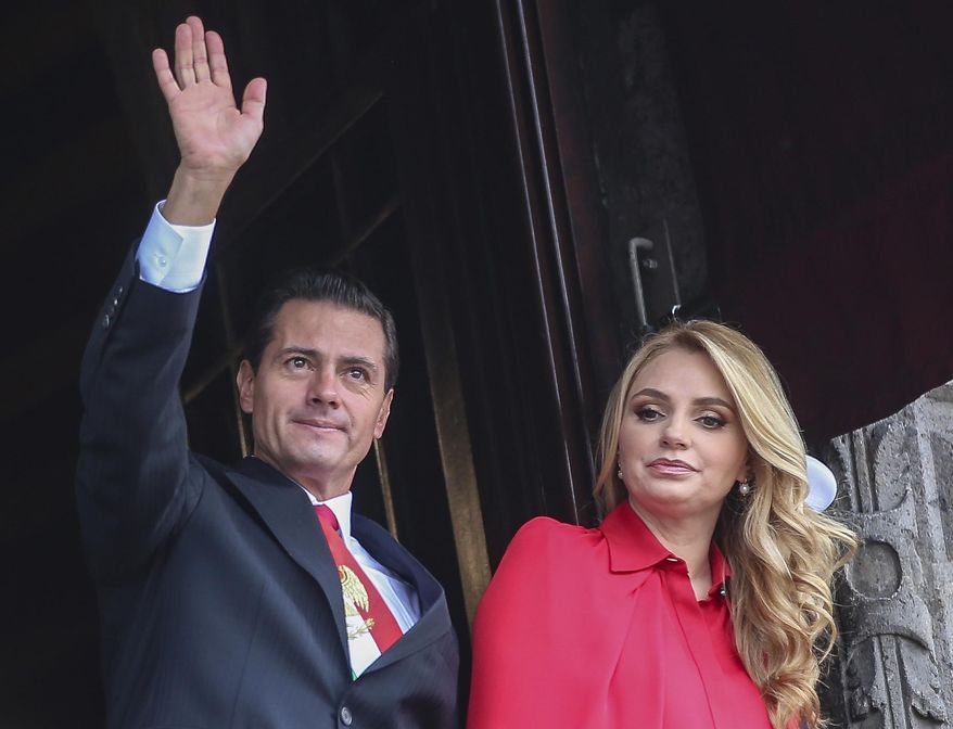 FILE - In this Sept. 16, 2018 file photo, Mexico&#39;s President Enrique Pena Nieto waves from a National Palace balcony, accompanied by first lady Angelica Rivera, during the Independence Day military parade in the Zocalo of Mexico City. Rivera posted on her Instagram account on Friday, Feb. 8, 2019, that she is divorcing Pena Nieto. (AP Photo/Anthony Vazquez, File)