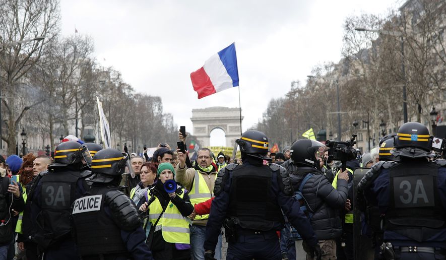 Yellow vest protesters walk down the famed Champs Elysees avenue to keep pressure on French President Emmanuel Macron's government, for the 13th straight weekend of demonstrations, in Paris, France, Saturday, Feb. 9, 2019. (AP Photo/Kamil Zihnioglu)