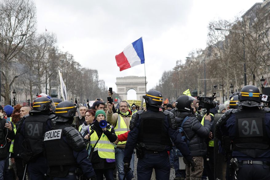 Yellow vest protesters walk down the famed Champs Elysees avenue to keep pressure on French President Emmanuel Macron's government, for the 13th straight weekend of demonstrations, in Paris, France, Saturday, Feb. 9, 2019. (AP Photo/Kamil Zihnioglu)