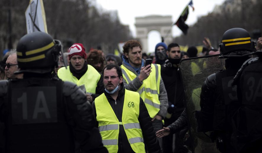 Yellow vest protesters walk down the famed Champs Elysees avenue to keep pressure on French President Emmanuel Macron's government, for the 13th straight weekend of demonstrations, in Paris, France, Saturday, Feb. 9, 2019. (AP Photo/Kamil Zihnioglu)
