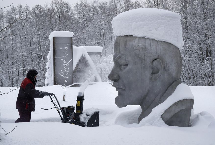 A worker uses a snowblower to clear the area around a statue of Soviet Union founder Vladimir Lenin at the Lenin Hut Museum in a forest near Razliv Lake, outside St. Petersburg, Russia, Monday, Feb. 4, 2019. Another cyclone caused a week of snowfall in St. Petersburg. (AP Photo/Dmitri Lovetsky)