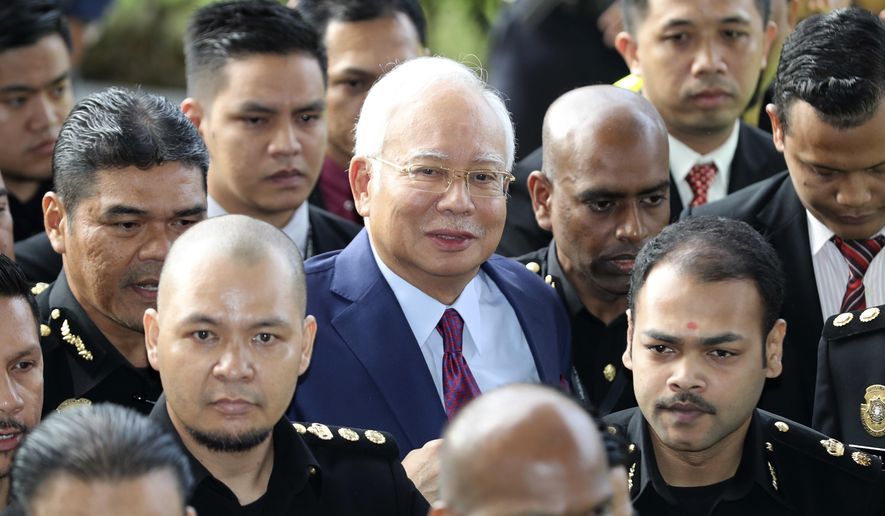 FILE - In this July 4, 2018, file photo, former Malaysian Prime Minister Najib Razak, center, arrives at a court house in Kuala Lumpur, Malaysia. Najib is hardly lying low ahead of his corruption trial set to begin Tuesday, Feb. 12, 2019, on charges related to the multibillion-dollar looting of the 1MDB state investment fund. He’s crooned about slander in an R&amp;amp;B video and vilified the current government on social media to counter portrayals of him as corrupt and out of touch. Najib denies wrongdoing and his lawyers are seeking delay.(AP Photo/Vincent Thian, File)
