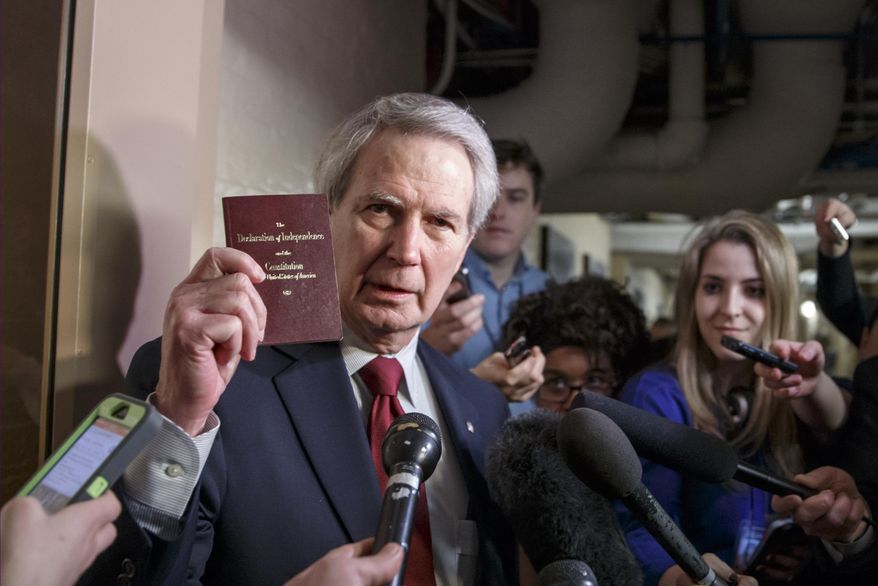 FILE - In this Thursday, Feb. 26, 2015, file photo, U.S. Rep. Walter B. Jones Jr., R-N.C., holds up a copy of the Constitution while talking to reporters as House Republicans emerge from a closed-door meeting on how to deal with the impasse over the Homeland Security budget, at the Capitol in Washington. Jones, a once-fervent supporter of the 2003 invasion of Iraq who later became an equally outspoken Republican critic of the war, died Sunday, Feb. 10, 2019, his 76th birthday. (AP Photo/J. Scott Applewhite, File)