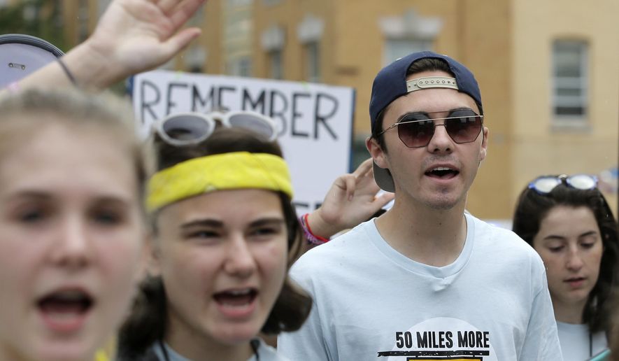 FILE - In this Aug. 23, 2018, file photo, David Hogg, 18, center right, a survivor of the school shooting at Marjory Stoneman Douglas High School, in Parkland, Fla., walks in a planned 50-mile march in Worcester, Mass. Hogg, became the most prominent spokesman for March for Our Lives, a group he and other Stoneman Douglas students founded that is pushing for stronger gun laws. (AP Photo/Steven Senne, File)