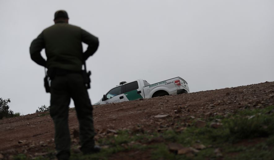 Border Patrol agent Vincent Pirro looks on near where a border wall ends that separates the cities of Tijuana, Mexico, and San Diego, Tuesday, Feb. 5, 2019, in San Diego. President Donald Trump is expected to speak about funding for a wall along the U.S.-Mexico border during his State of the Union address Tuesday. (AP Photo/Gregory Bull)