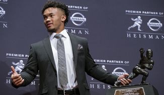 FILE - In this Dec. 8, 2018, file photo, Oklahoma quarterback Kyler Murray holds the Hesiman Trophy after winning the award in New York. Murray&#x27;s locker remained empty on Monday, Feb. 11, 2019, in the spring training clubhouse of the Oakland Athletics, who say they are uncertain when or if the Heisman Trophy winner will report to the baseball team he signed with last summer. Billy Beane, Oakland’s executive vice president of baseball operation, said talks are continuing with Murray, who may drop baseball to pursue an NFL career. (AP Photo/Craig Ruttle, File) **FILE**
