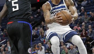 Minnesota Timberwolves&#39; Derrick Rose, right, eyes the basket on a layup as Los Angeles Clippers&#39; Montrezl Harrell defends in the first half of an NBA basketball game Monday, Feb. 11, 2019, in Minneapolis. (AP Photo/Jim Mone)