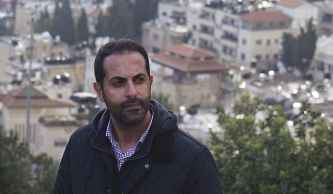 Lawyer Alaa Mahajna poses for a photo on Mount Scopus, overlooking Jerusalem, on Saturday, Feb. 9, 2019. Mahajna was one of at least half a dozen people targeted by a mysterious group of undercover operatives over the past couple of months. All of them have crossed paths, in some way, with the NSO Group, a spyware maker that Mahajna is suing in Israeli court. (AP Photo/Raphael Satter)