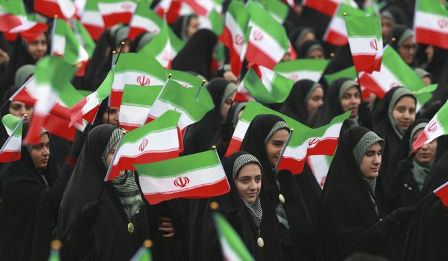 Iranians wave national flags during a ceremony celebrating the 40th anniversary of the Islamic Revolution, at the Azadi, or Freedom, Square, in Tehran, Iran, Monday, Feb. 11, 2019. On Feb. 11, 1979. Iran&#x27;s military stood down after days of street battles, allowing the revolutionaries to sweep across the country, and the government of Shah Mohammad Reza Pahlavi resigned. (AP Photo/Vahid Salemi)