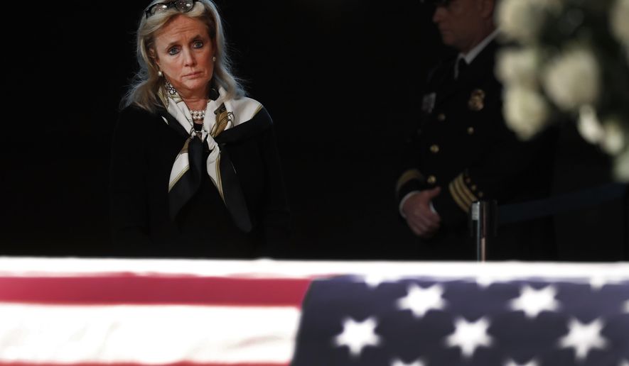 Rep. Debbie Dingell, D-Mich., stands at the casket of her husband and former Rep. John Dingell, lying in repose in Dearborn, Mich., Monday, Feb. 11, 2019. John Dingell, the longest-serving member of Congress in American history, was first elected in 1955 and retired in 2014. The Democrat was 92. (AP Photo/Paul Sancya)