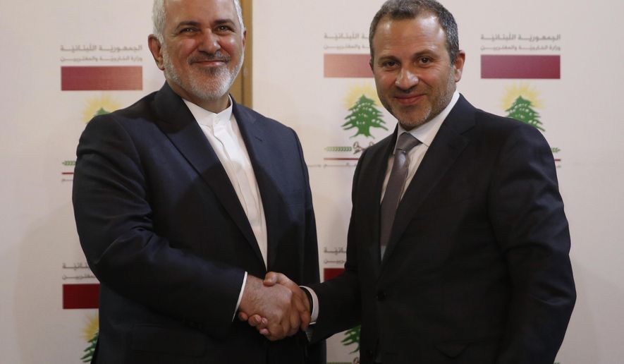Lebanese Foreign Minister Gebran Bassil, right, shakes hands with his Iranian counterpart Mohammad Javad Zarif, in Beirut, Lebanon, Monday, Feb. 11, 2019. Zarif extended an offer for Iranian military assistance to the U.S.-backed Lebanese army on Sunday, saying Iran is ready to assist in all sectors should the Lebanese government want it. (AP Photo/Hussein Malla)