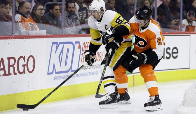 Pittsburgh Penguins&#x27; Sidney Crosby (87) and Philadelphia Flyers&#x27; Travis Sanheim (6) battle for the puck during the first period of an NHL hockey game, Monday, Feb. 11, 2019, in Philadelphia. (AP Photo/Matt Slocum)