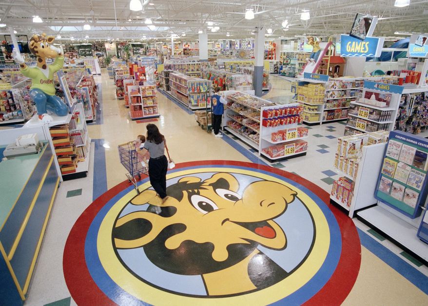 In this July 30, 1996, file photo, a woman pushes a shopping cart over a graphic of Toys R Us mascot Geoffrey the giraffe at the Toys R Us store in Raritan, N.J. Richard Barry, a former Toys R Us executive and now CEO of the new company called Tru Kids Inc., is exploring freestanding stores, shops within existing stores as well as e-commerce. Tru Kids, owned by former investors of Toys R Us, will manage the Toys R Us, Babies R Us and Geoffrey brands. (AP Photo/Daniel Hulshizer, File)