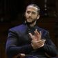 In this Oct. 11, 2018, file photo, former NFL football quarterback Colin Kaepernick applauds while seated on stage during W.E.B. Du Bois Medal ceremonies at Harvard University in Cambridge, Mass. (AP Photo/Steven Senne, File) 