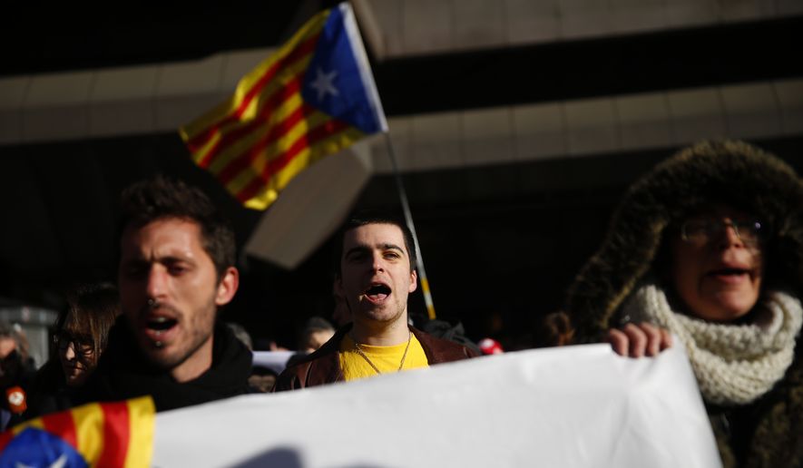 Pro independence demonstrators gather outside the Spanish Supreme Court in Madrid, Tuesday, Feb. 12, 2019. Spain is bracing for the nation's most sensitive trial in four decades of democracy this week, with a dozen Catalan separatists facing charges including rebellion over a failed secession bid in 2017. (AP Photo/Andrea Comas)
